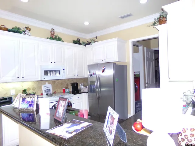 a kitchen with refrigerator and cabinets