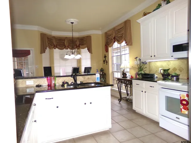a kitchen with a sink stove and white cabinets