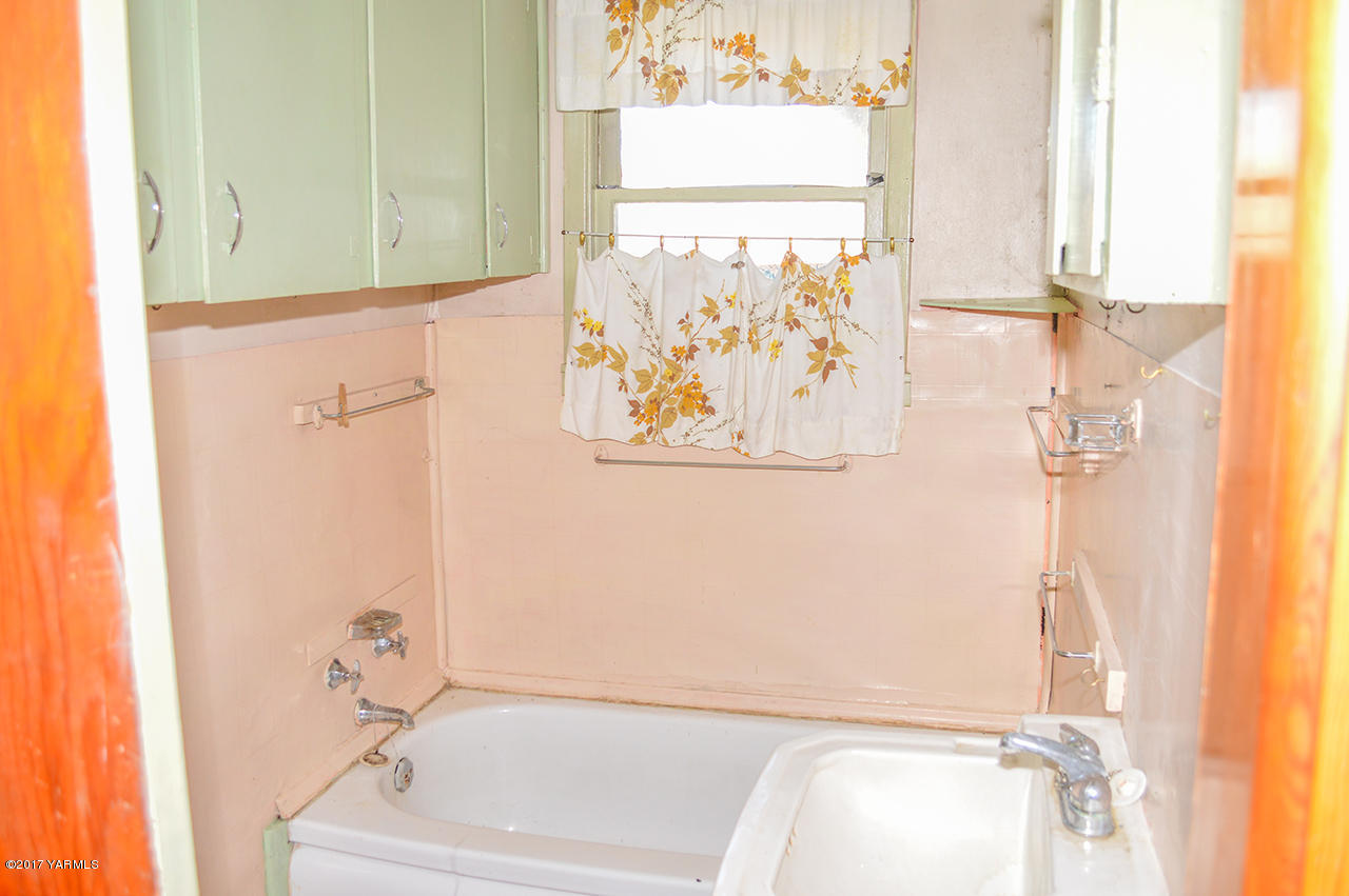 1061 Nightingale Road Wapato, WA 98951 - Photo 12 of 20 a bathroom with a bathtub and a window