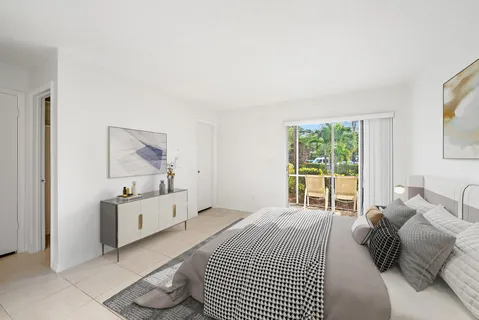 a bedroom with a bed and a dresser next to a window