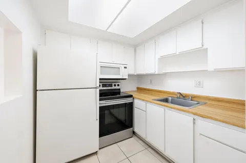 a kitchen with a refrigerator sink stove and cabinets