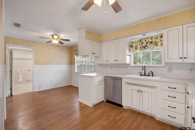 a kitchen with cabinets wooden floor and a window