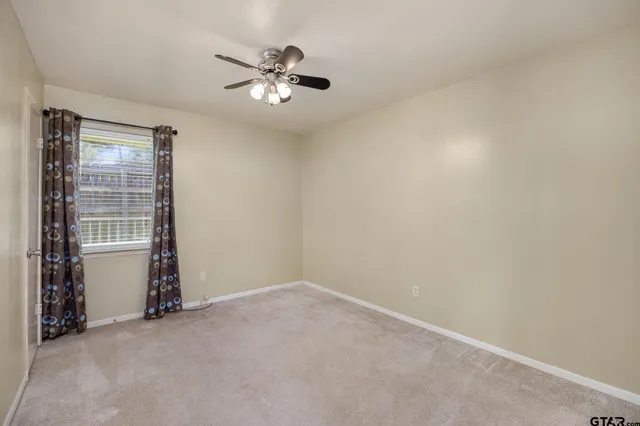 a view of an empty room with a window and fireplace