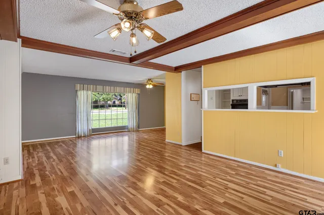 a view of a livingroom with wooden floor and a ceiling fan