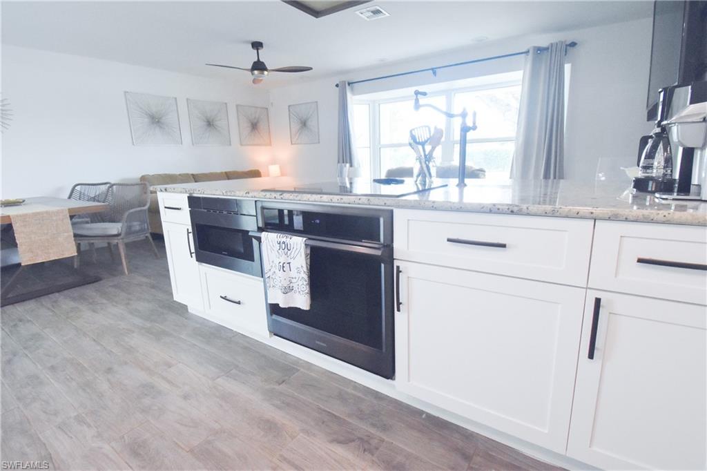 3131 Calusa Avenue Naples, FL 34112 - Photo 18 of 26 a kitchen with a stove a sink and a window