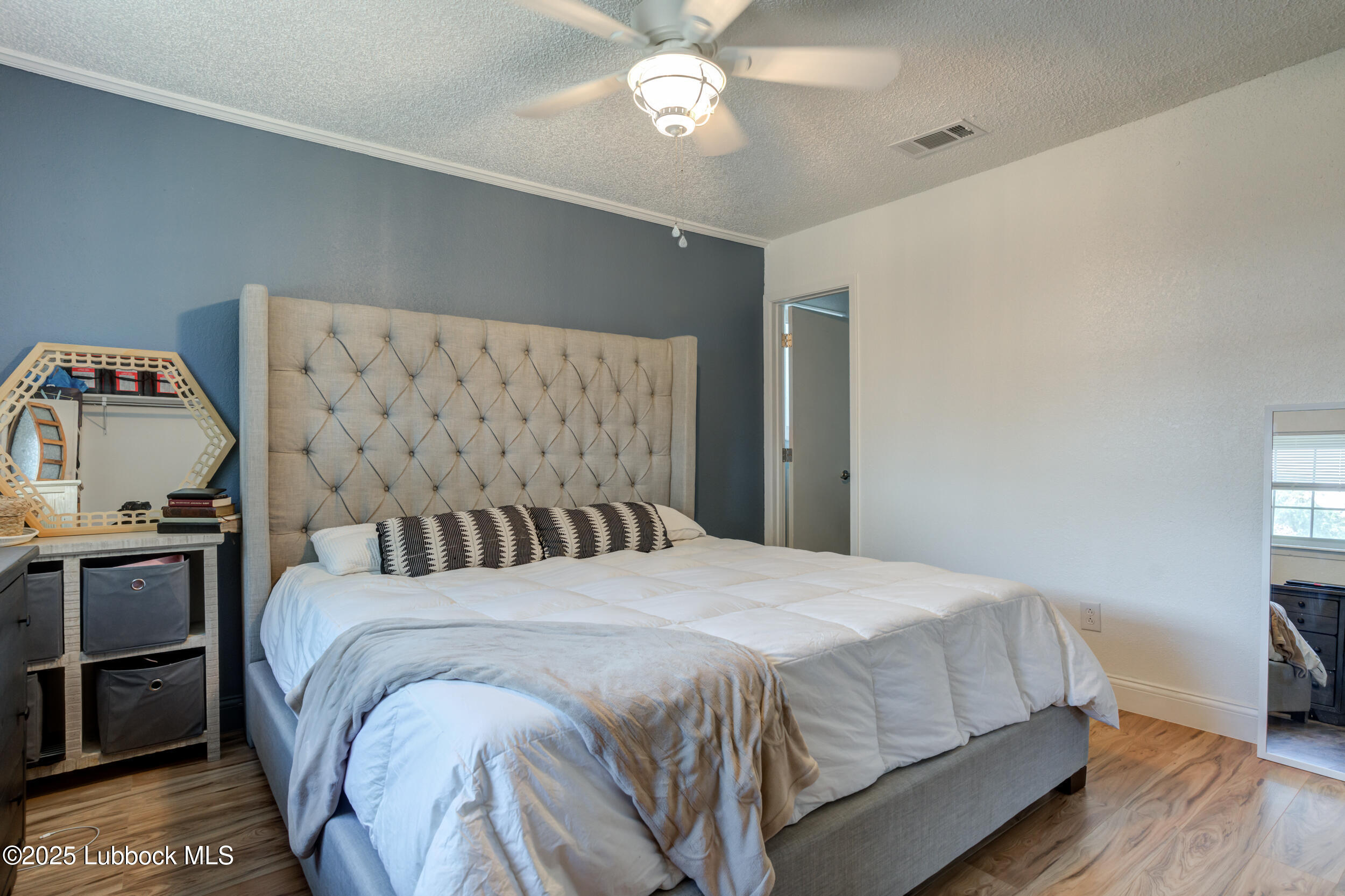 6403 28th Street Lubbock, TX 79407 - Photo 16 of 27 a bedroom with a bed and wooden floor
