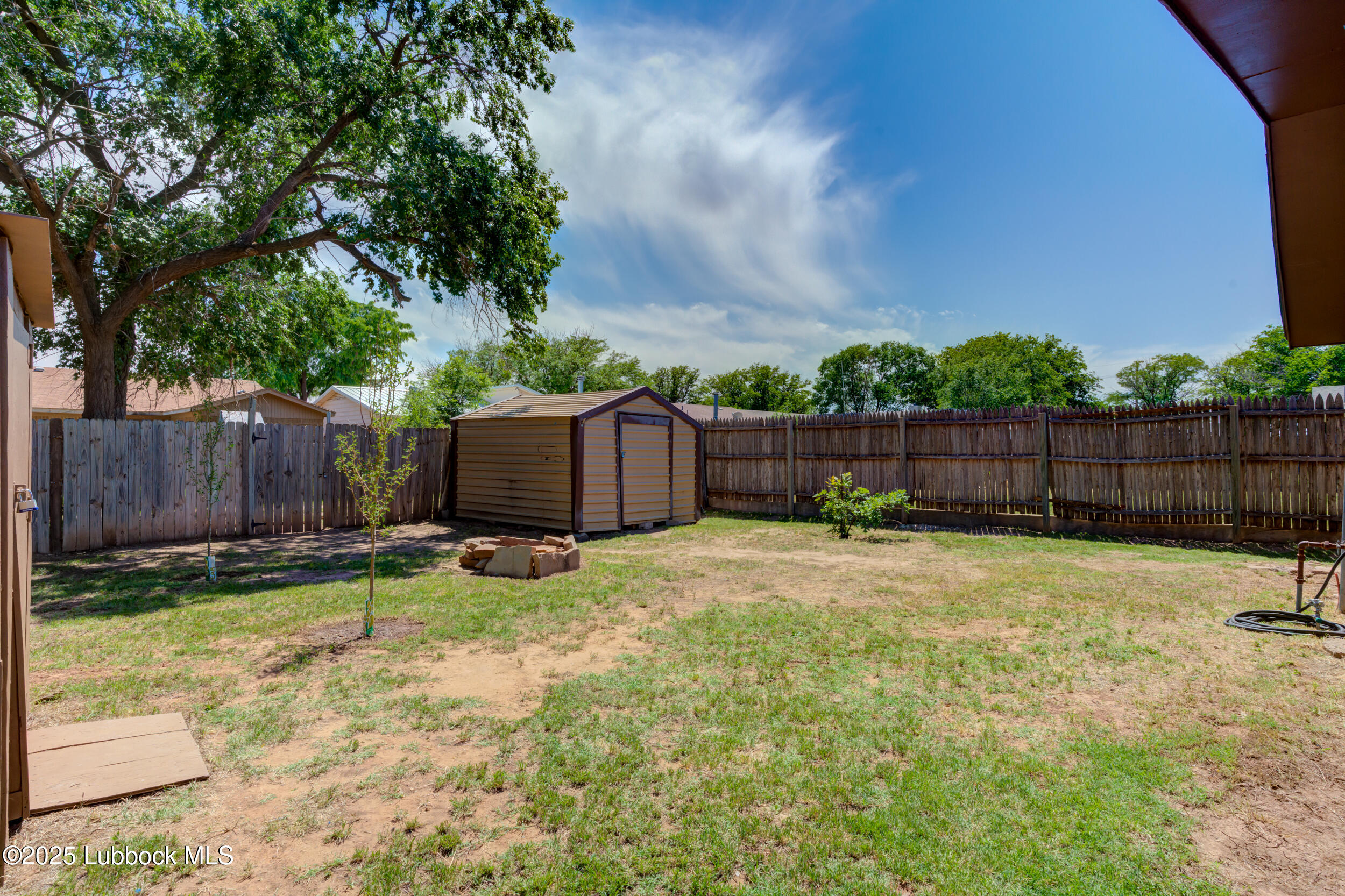 6403 28th Street Lubbock, TX 79407 - Photo 26 of 27 a backyard with wooden fence and a large tree