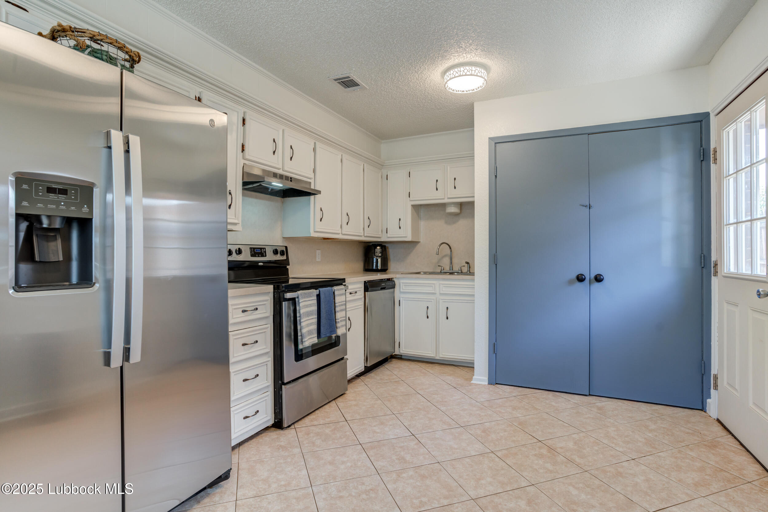 6403 28th Street Lubbock, TX 79407 - Photo 8 of 27 a kitchen with stainless steel appliances a refrigerator sink and cabinets