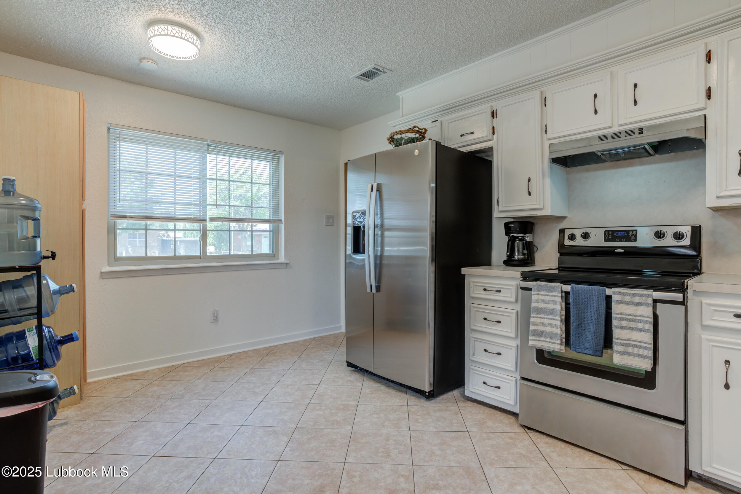 6403 28th Street Lubbock, TX 79407 - Photo 9 of 27 a kitchen with stainless steel appliances granite countertop a refrigerator and a stove