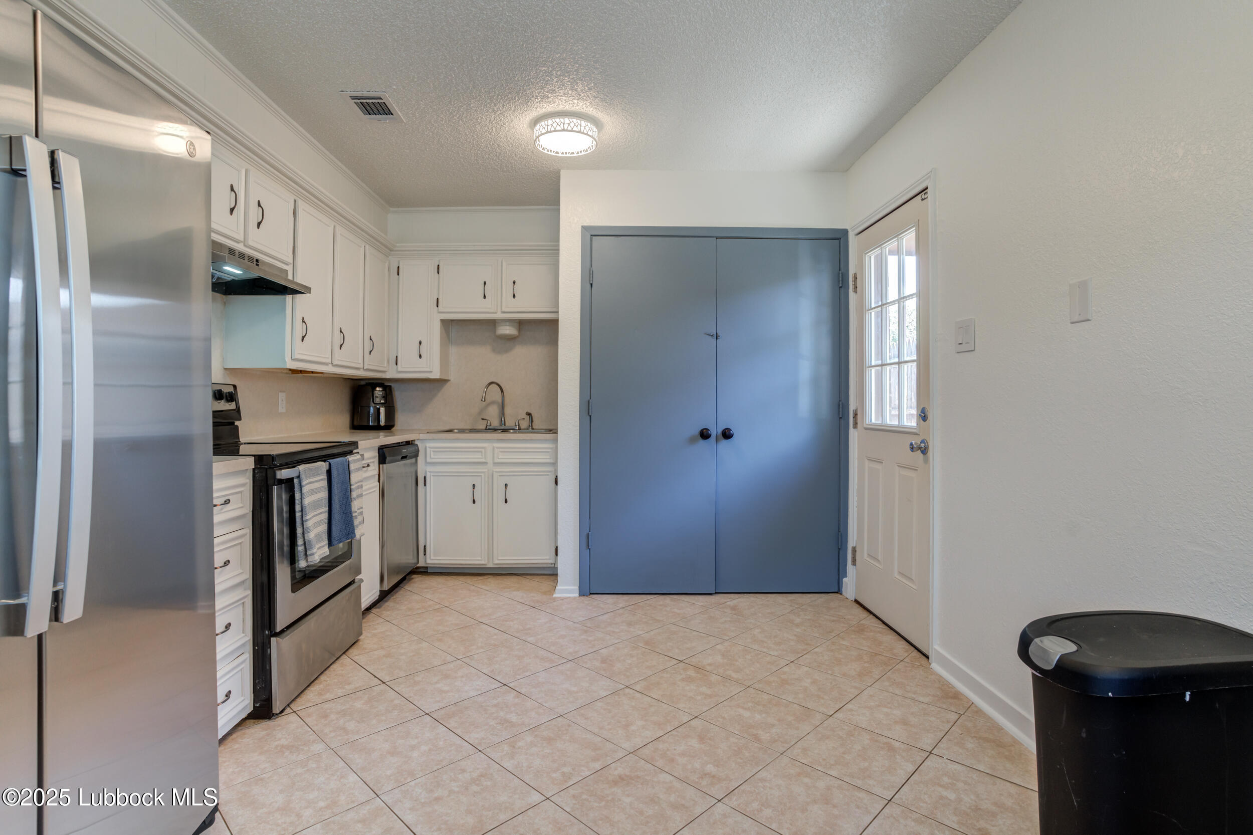 6403 28th Street Lubbock, TX 79407 - Photo 10 of 27 a kitchen with a refrigerator and a stove