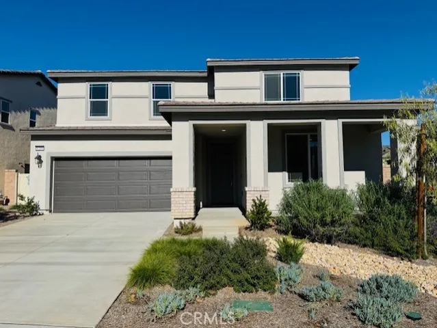 a front view of a house with yard and parking