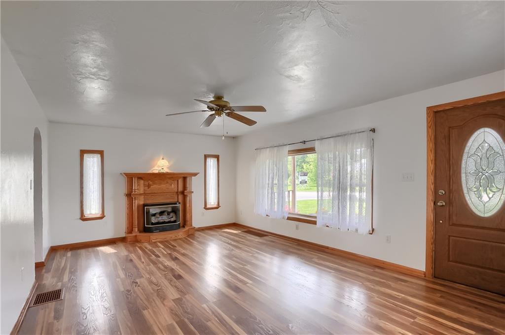 1081 Evans City Road Renfrew, PA 16053 - Photo 9 of 24 an empty room with windows fireplace and wooden floor