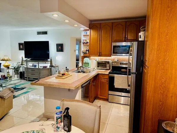 a kitchen with stainless steel appliances a stove sink microwave and refrigerator