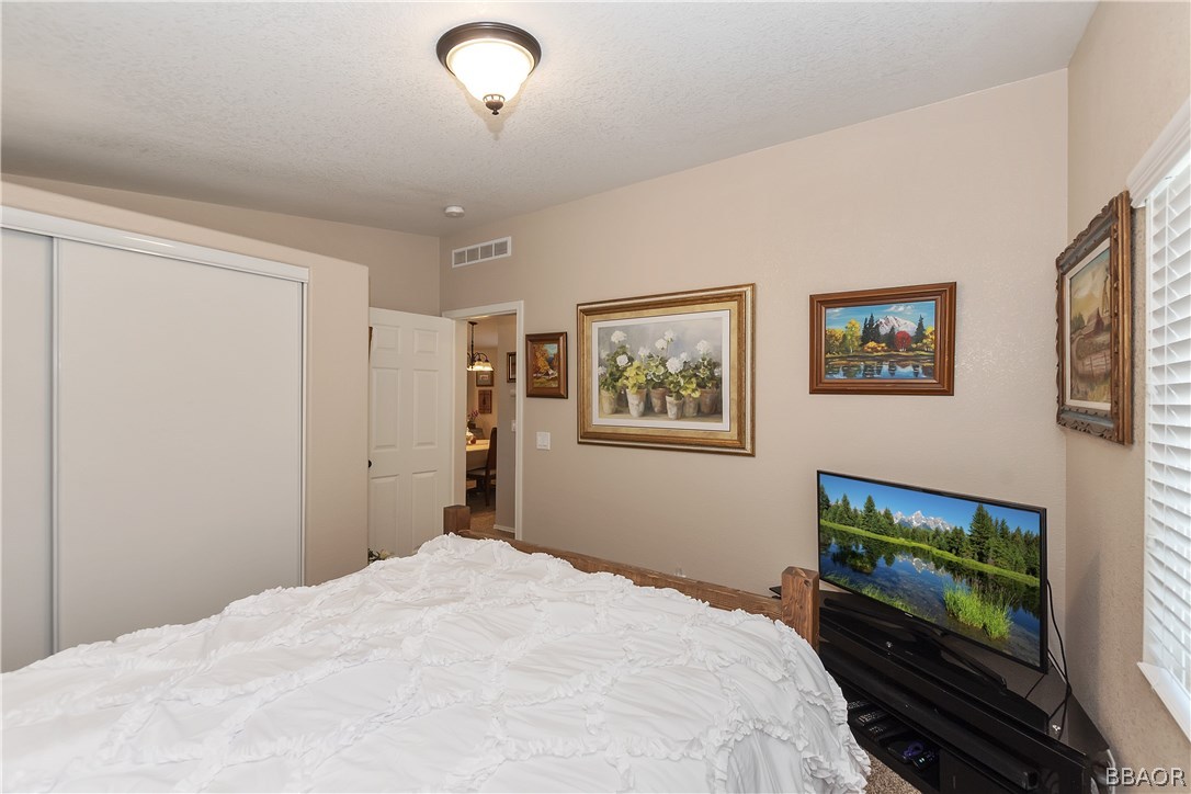 547 Alden Road, Unit 33 Big Bear Lake, CA 92315 - Photo 20 of 28 a bedroom with a bed and a flat screen tv