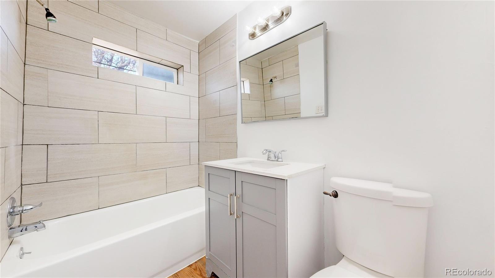 345 South Utica Street Denver, CO 80219 - Photo 11 of 19 a bathroom with a sink mirror toilet and bathtub