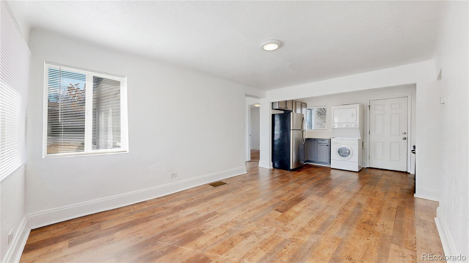 345 South Utica Street Denver, CO 80219 - Photo 2 of 19 a view of empty room with wooden floor and window
