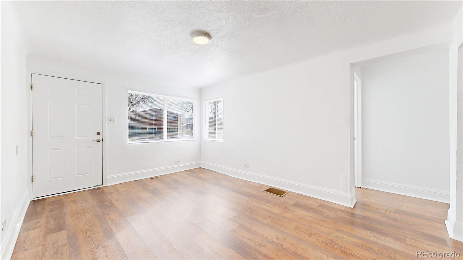 345 South Utica Street Denver, CO 80219 - Photo 4 of 19 an empty room with wooden floor and windows