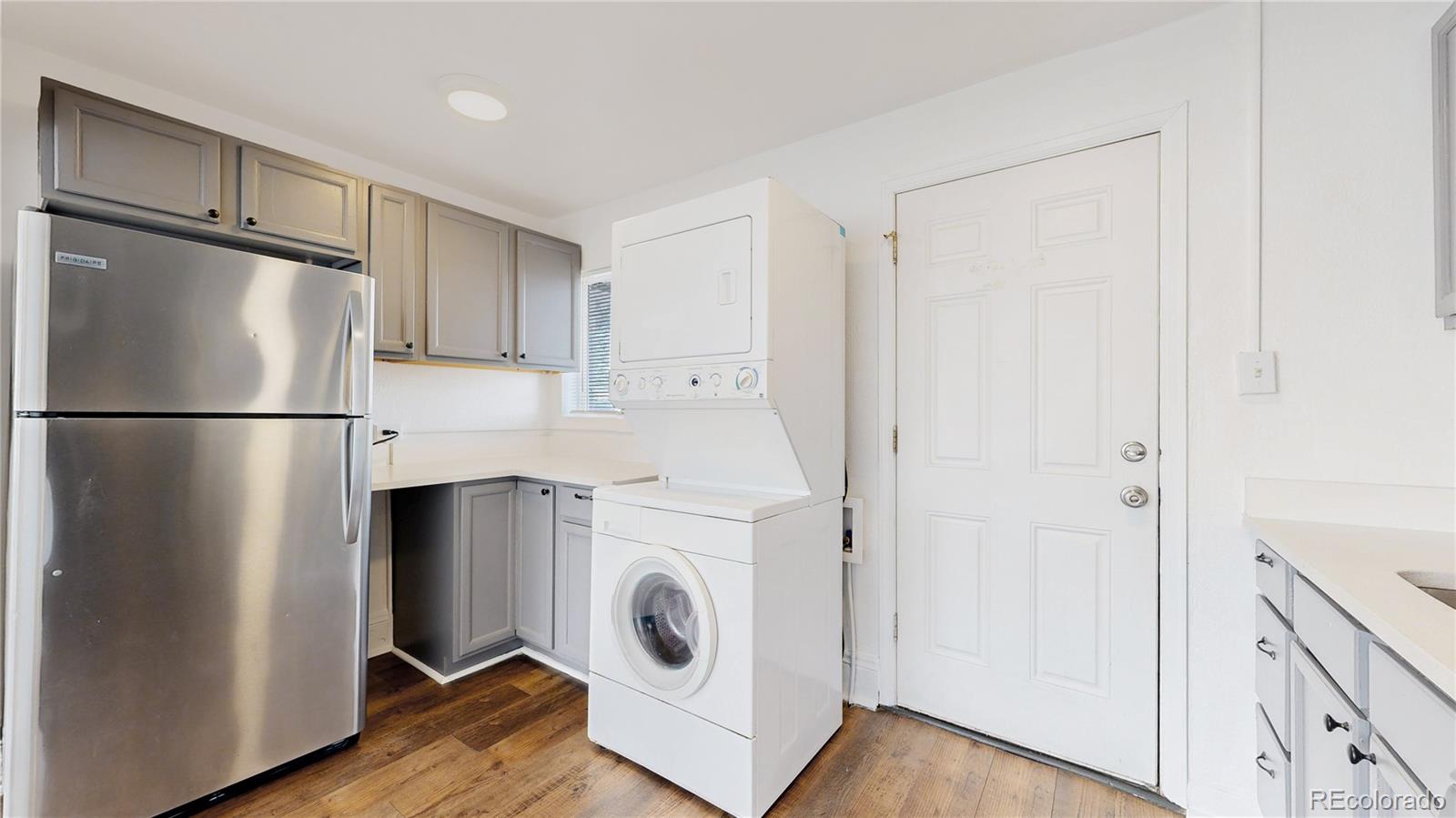 345 South Utica Street Denver, CO 80219 - Photo 5 of 19 a kitchen with a refrigerator a washer and dryer