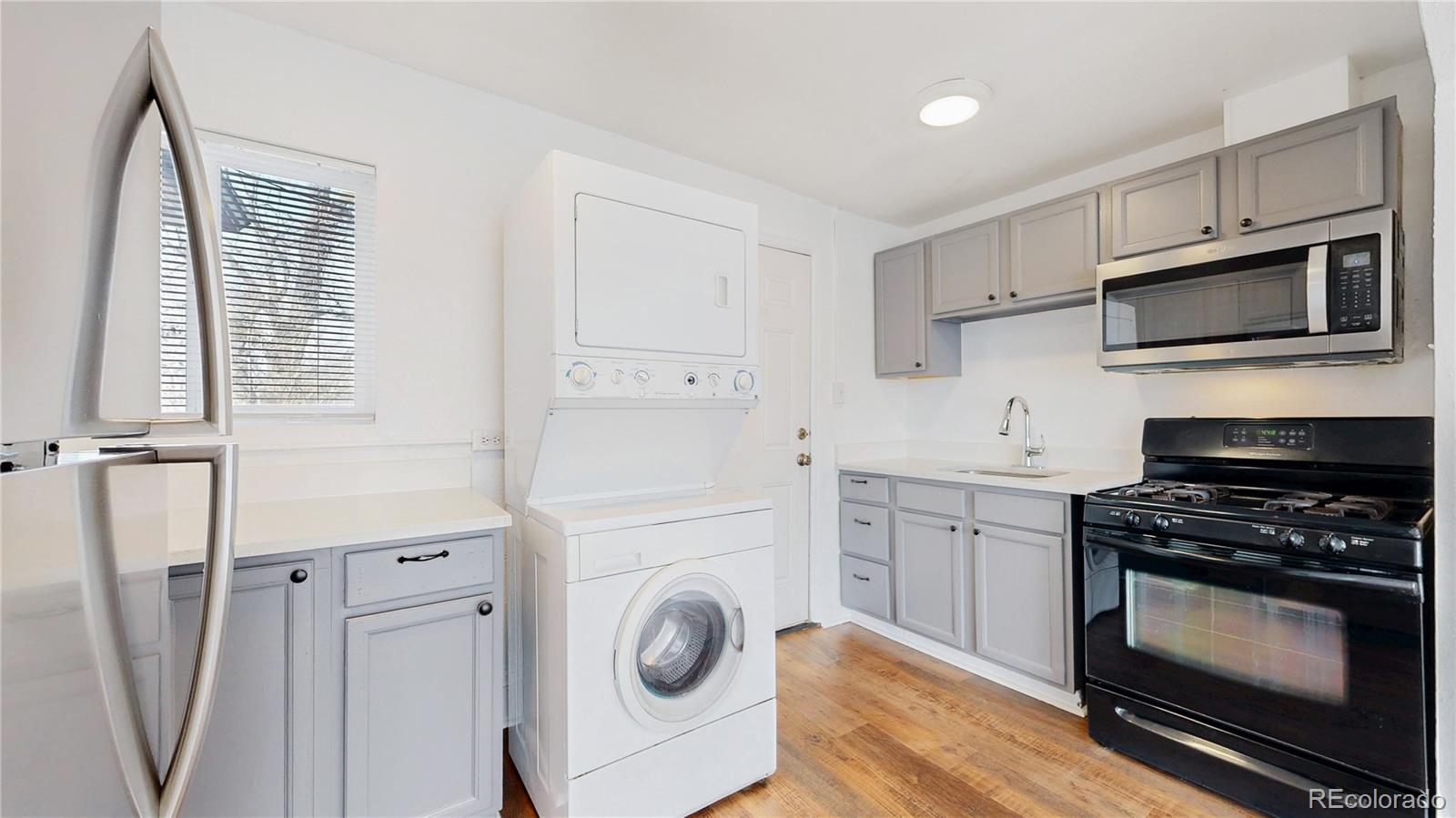 345 South Utica Street Denver, CO 80219 - Photo 6 of 19 a kitchen with cabinets and steel stainless steel appliances