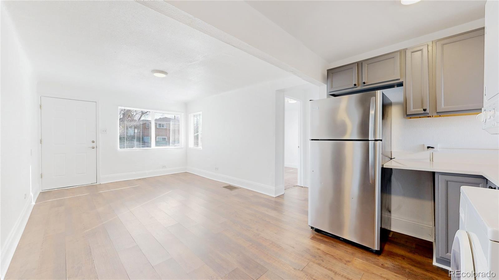 345 South Utica Street Denver, CO 80219 - Photo 7 of 19 a refrigerator freezer sitting in a kitchen with stainless steel appliances wooden floor and cabinets
