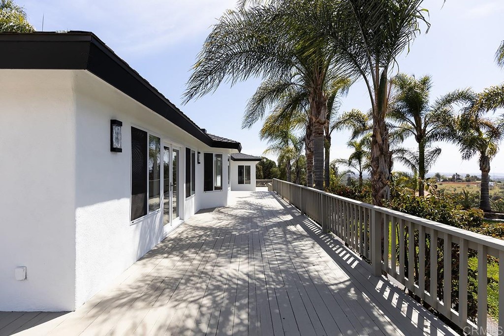 6949 Elfin Oaks Road Escondido, CA 92029 - Photo 19 of 24 a view of a house with a small yard and palm trees