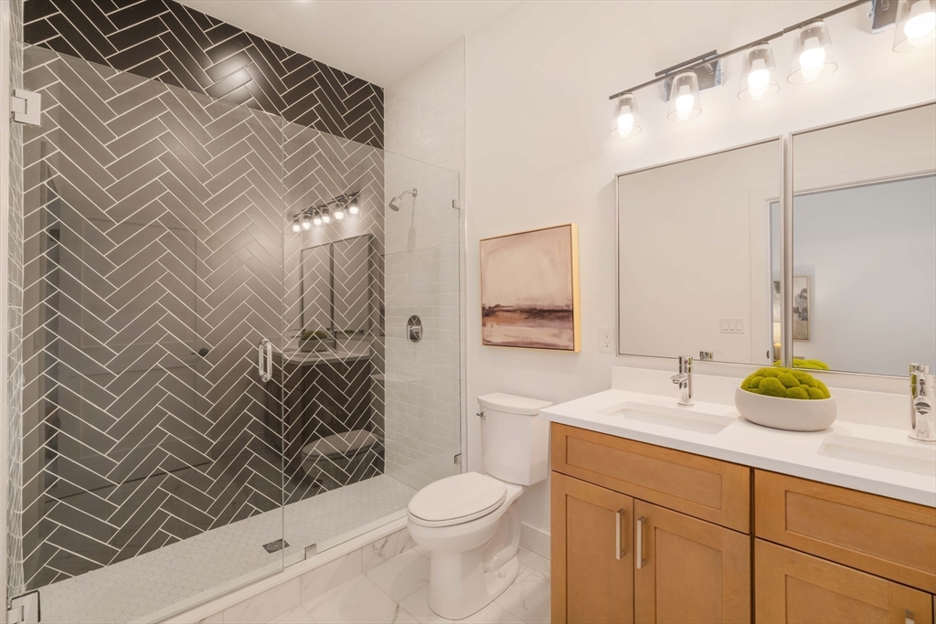 231 Everett Street, Unit 1 Boston, MA 02128 - Photo 19 of 25 a bathroom with a sink a toilet and shower