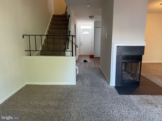 a view of hallway with stairs and wooden floor