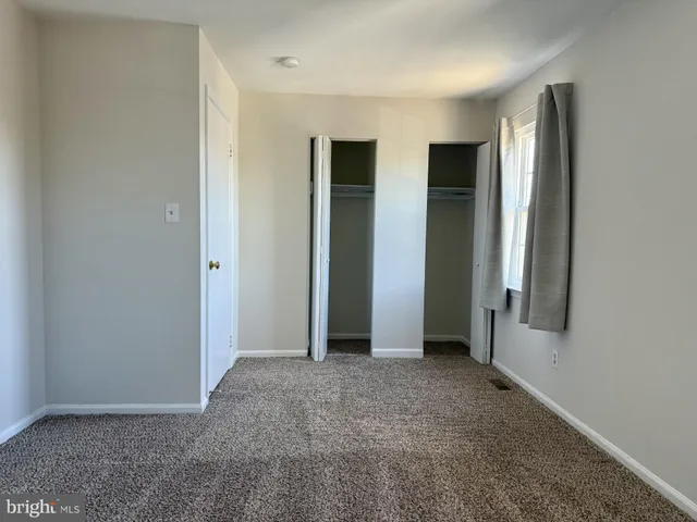 an empty room with windows and closet