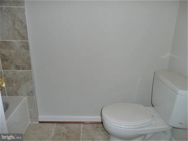 a white toilet sitting next to a bath tub