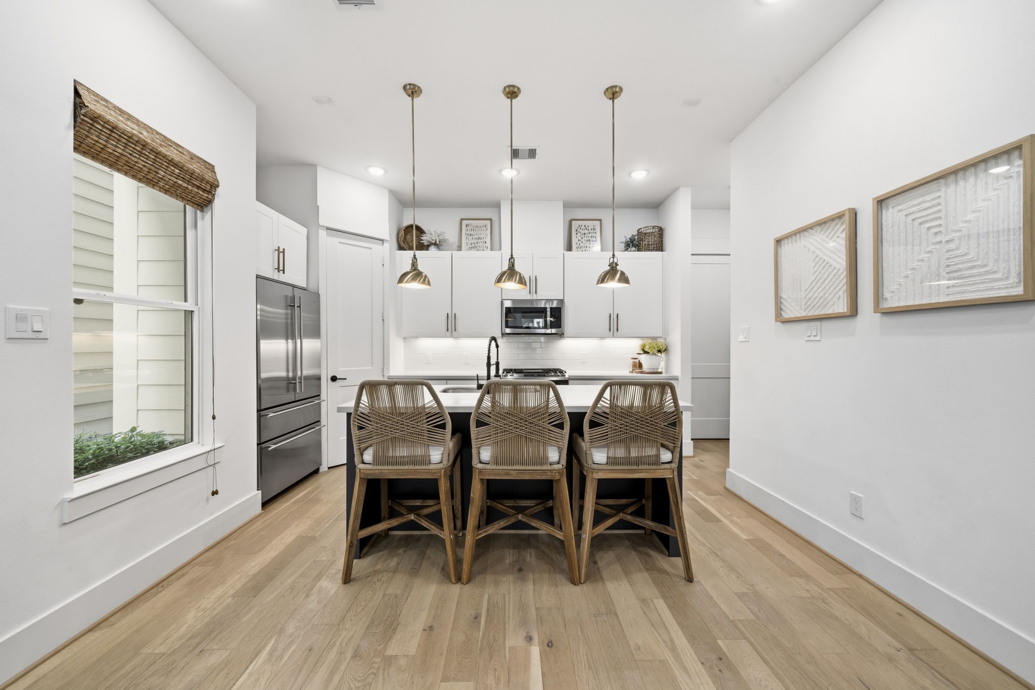 9018 Wellspring Drive Houston, TX 77080 - Photo 9 of 25 The heart of the home is this gourmet kitchen, anchored by a large island with designer pendant lighting and high-end stainless steel appliances, all set against beautiful engineered wood flooring.