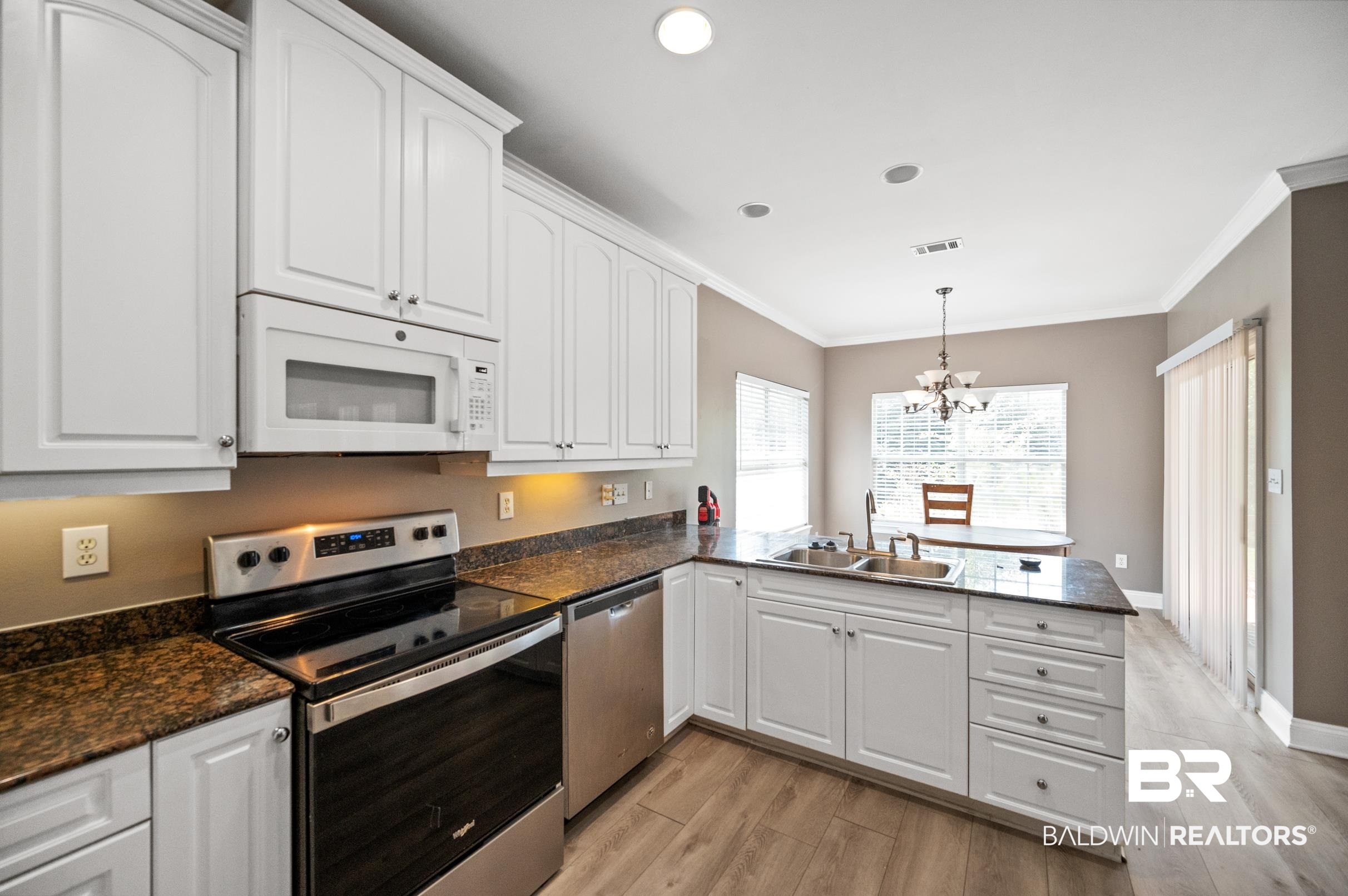 108 Natchez Trace Foley, AL 36535 - Photo 12 of 35 Kitchen featuring a notable chandelier, light hardwood / wood-style flooring, kitchen peninsula, sink, and appliances with stainless steel finishes