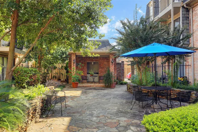 a view of a patio with chairs and table under an umbrella
