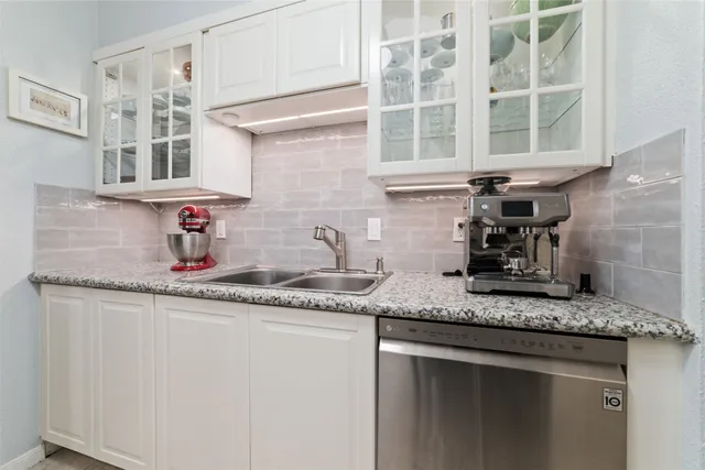 a kitchen with stainless steel appliances granite countertop a sink and cabinets