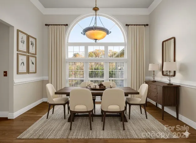 a dining room with furniture a chandelier and wooden floor