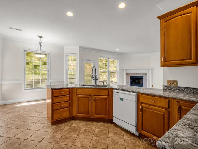 a large kitchen with stainless steel appliances granite countertop a stove a sink and a refrigerator
