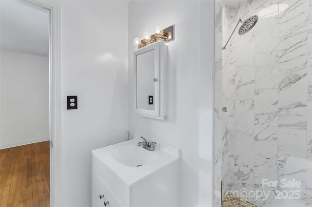 a bathroom with a sink a mirror and shower