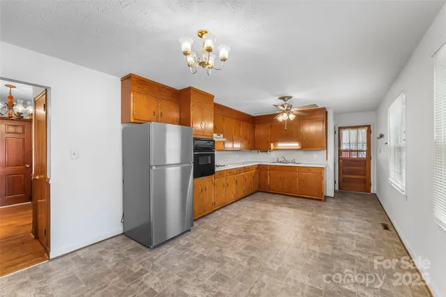 a kitchen with refrigerator and cabinets