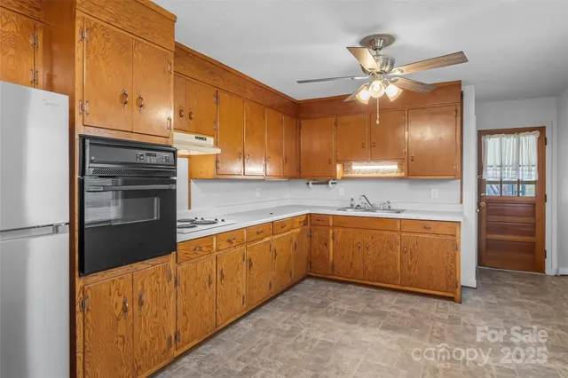 a kitchen with stainless steel appliances granite countertop a refrigerator a sink and dishwasher