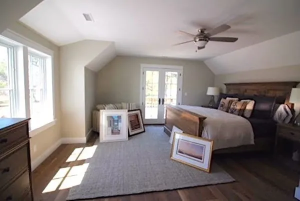 a spacious bedroom with a bed and a chandelier