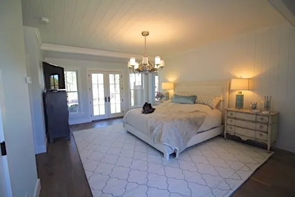 a spacious bedroom with a bed and a chandelier