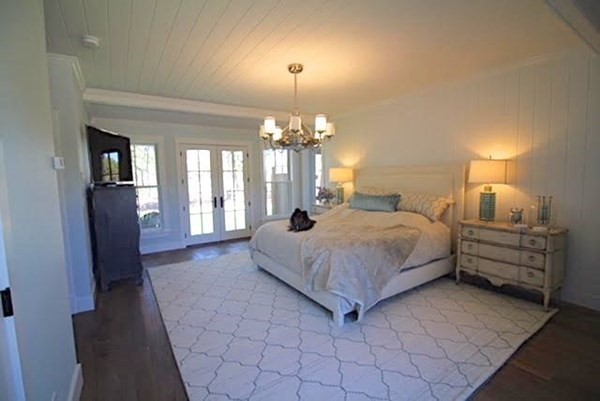 7 Mill Hill Farms Road Edgartown, MA 02539 - Photo 20 of 25 a spacious bedroom with a bed and a chandelier