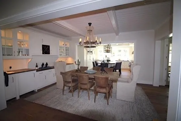 a kitchen with a dining table chairs and white cabinets