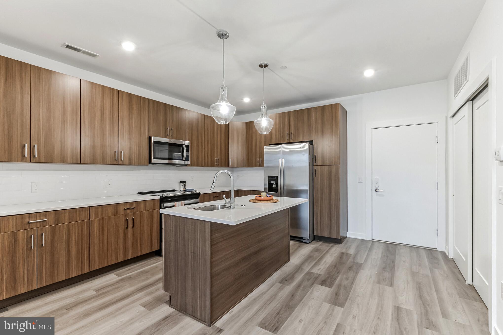 5801 Ridge Avenue, Unit 318 Philadelphia, PA 19128 - Photo 2 of 26 a kitchen with kitchen island a sink stainless steel appliances and cabinets