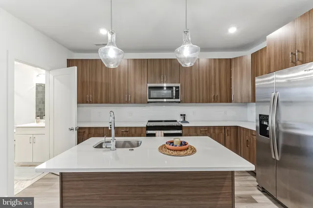 a kitchen with a kitchen island a sink stainless steel appliances and cabinets