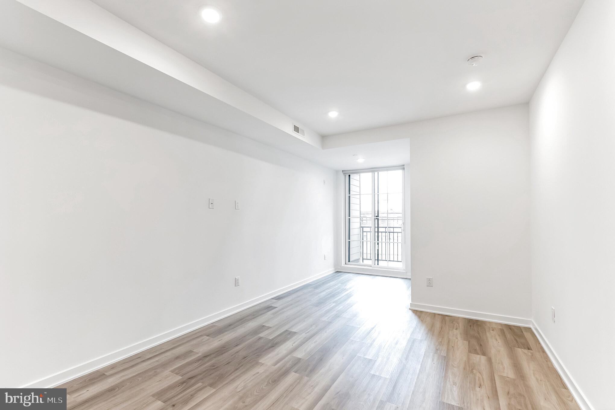 5801 Ridge Avenue, Unit 318 Philadelphia, PA 19128 - Photo 8 of 26 an empty room with wooden floor and windows