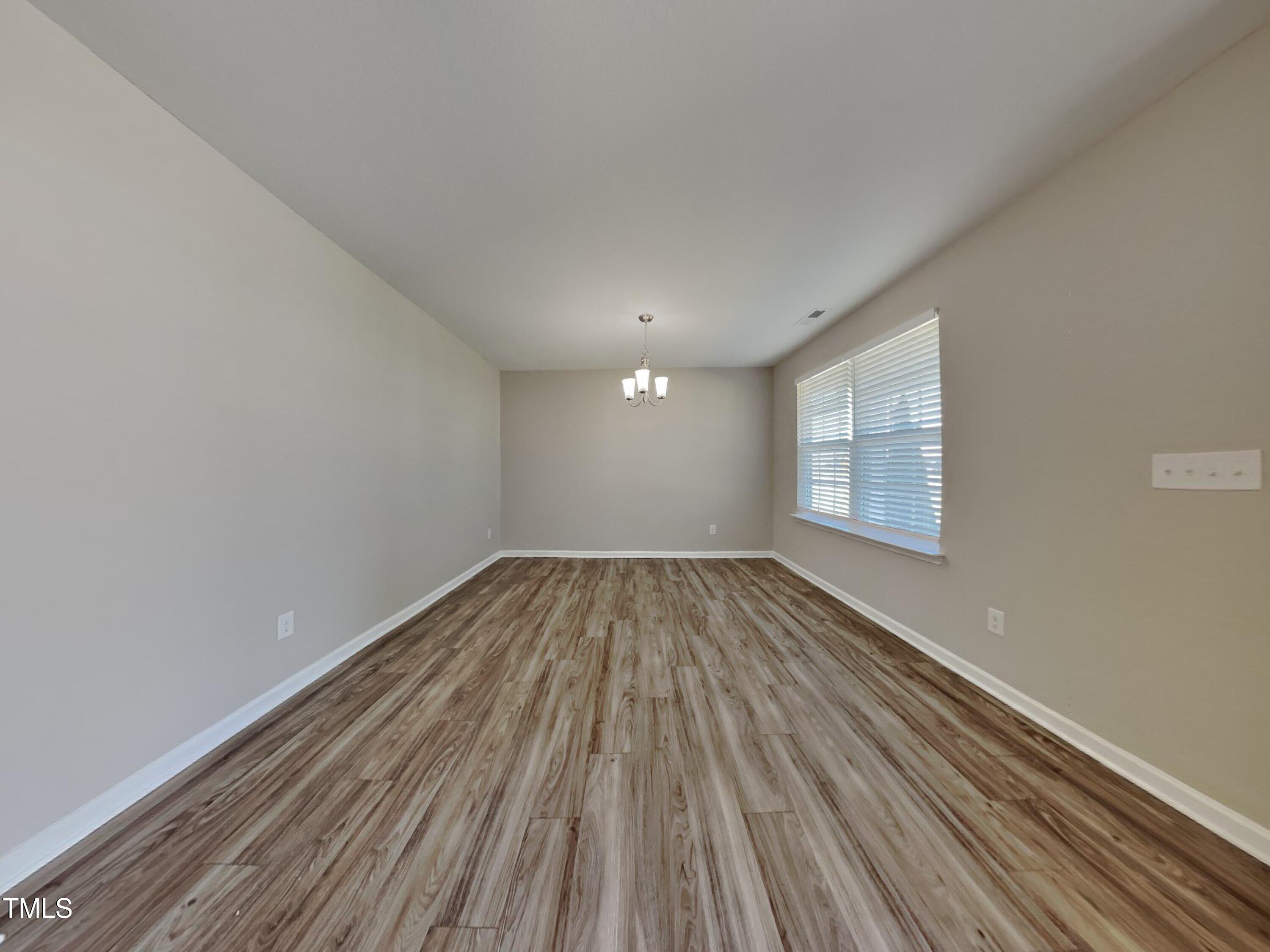 244 Botanical Court Bunnlevel, NC 28323 - Photo 16 of 18 a view of empty room with wooden floor and fan