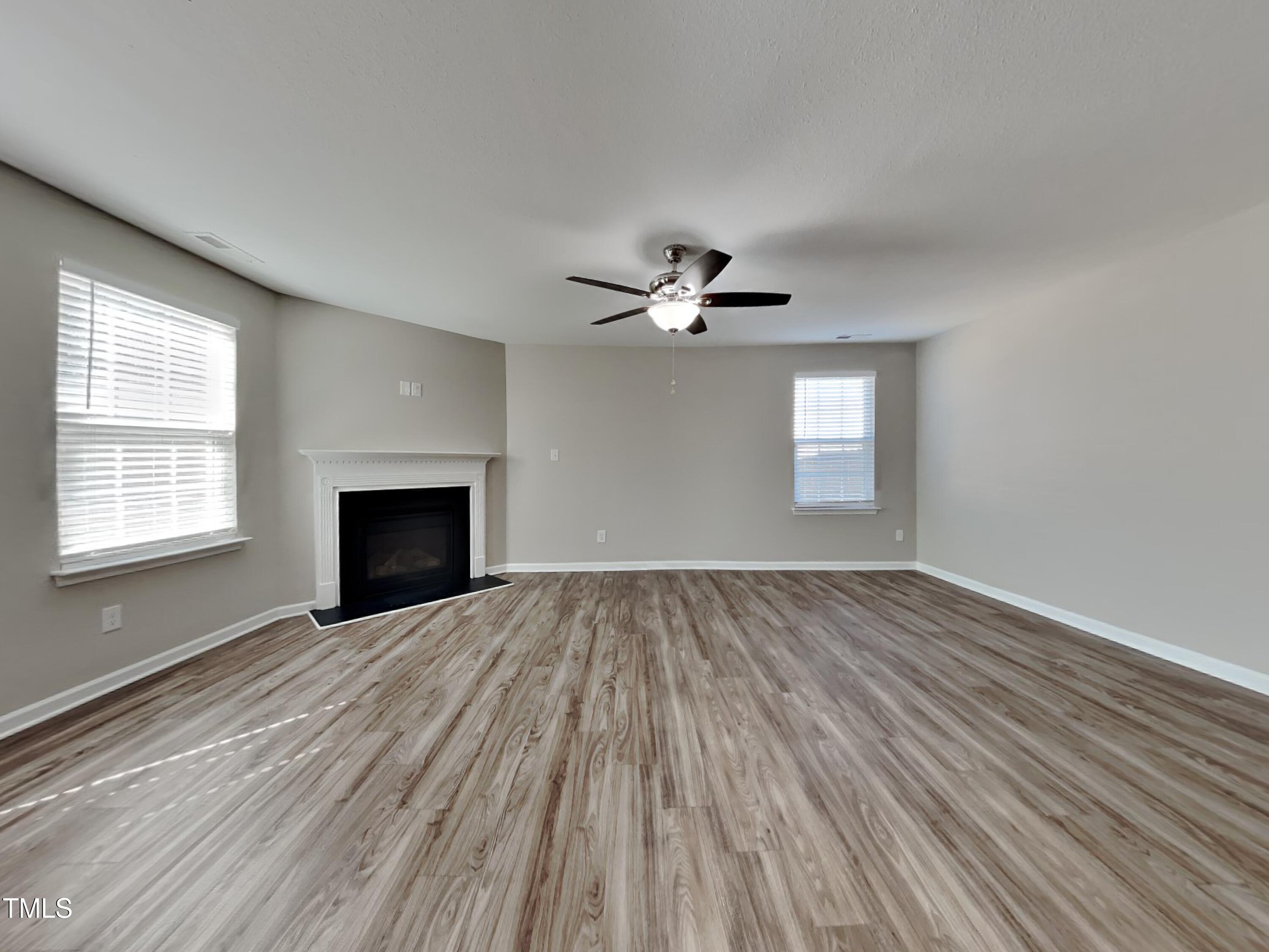 244 Botanical Court Bunnlevel, NC 28323 - Photo 2 of 18 a view of empty room with wooden floor and fireplace