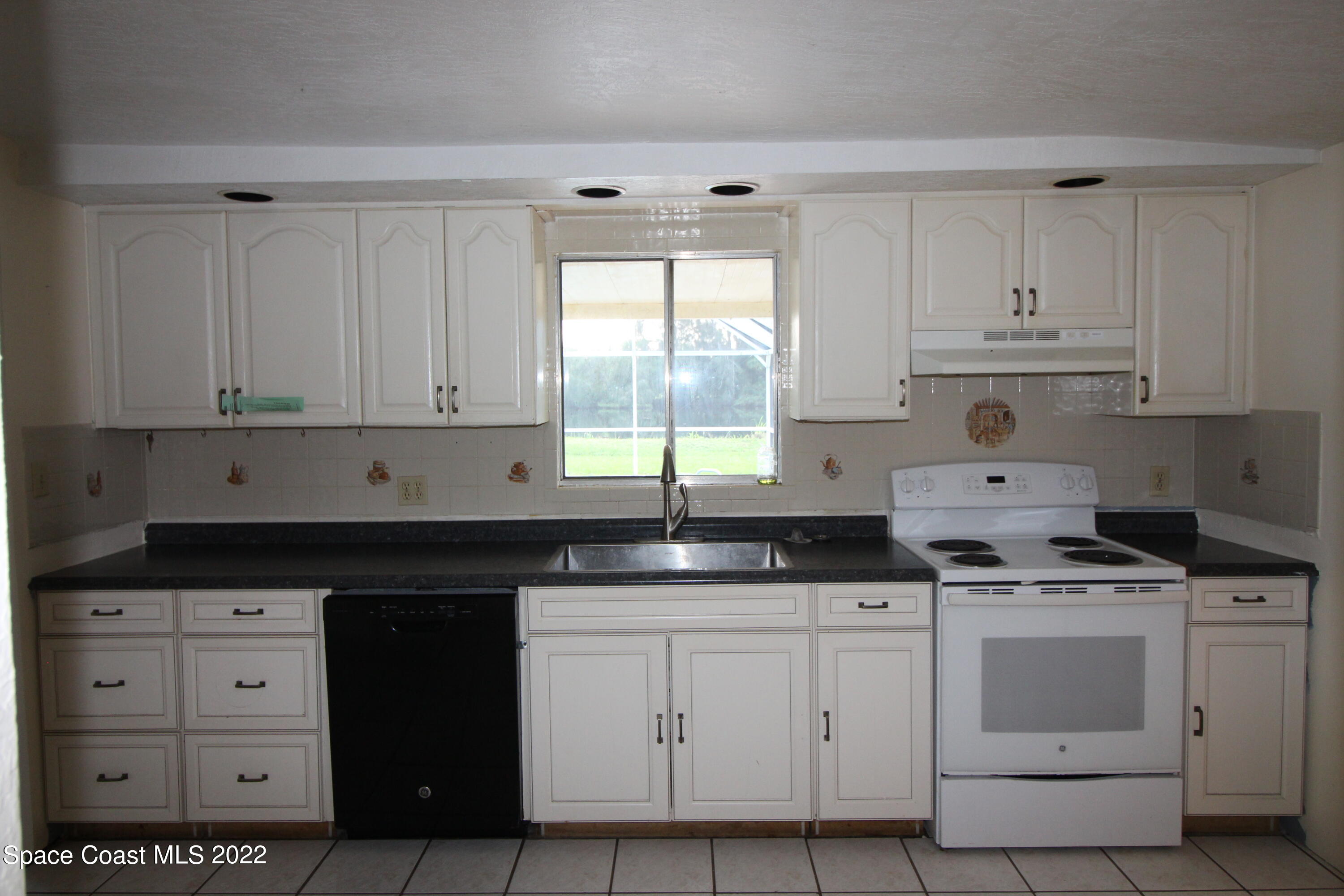 525 North Burnett Road Cocoa, FL 32926 - Photo 4 of 14 a kitchen with white cabinets and appliances