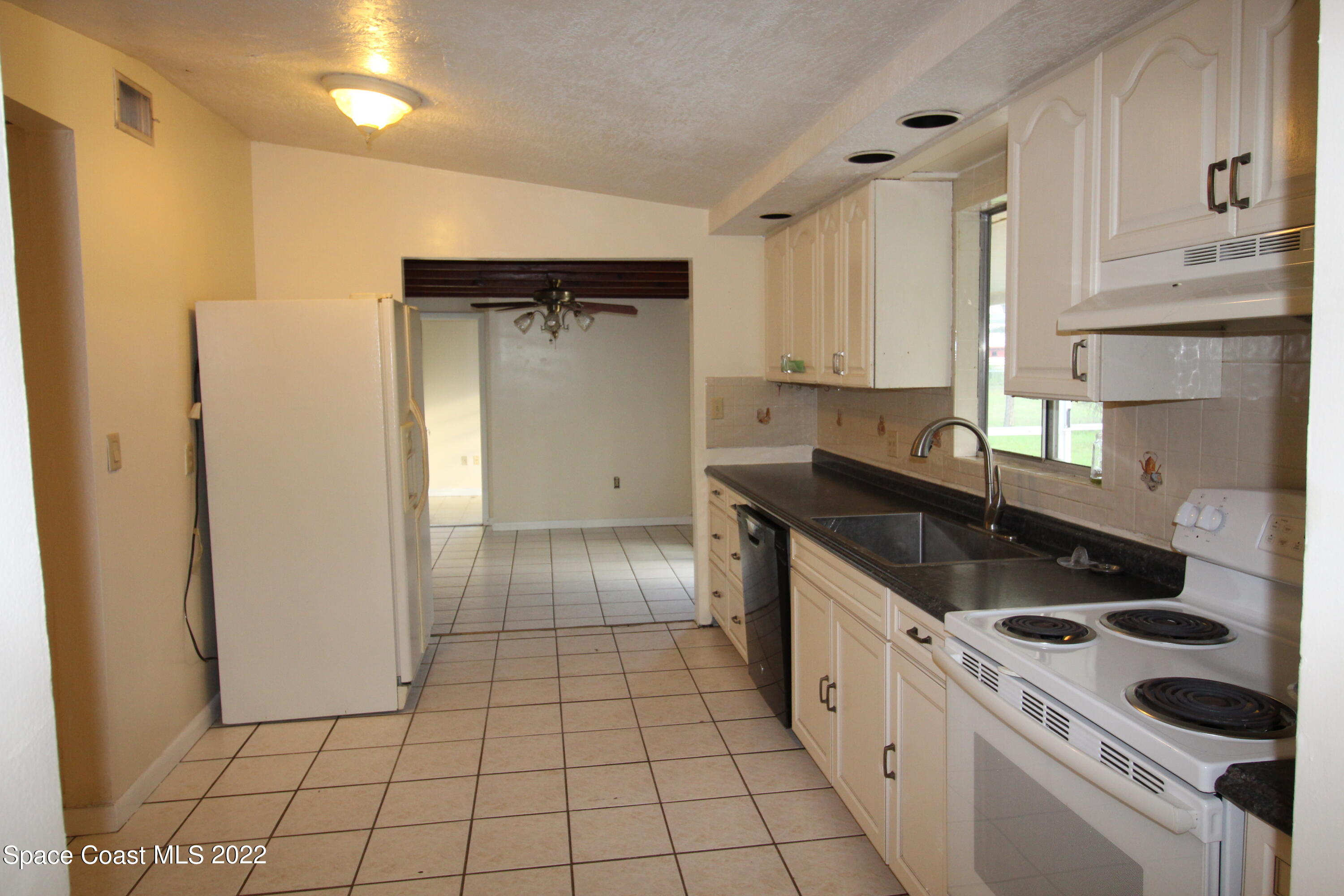 525 North Burnett Road Cocoa, FL 32926 - Photo 5 of 14 a kitchen with a sink a stove and refrigerator