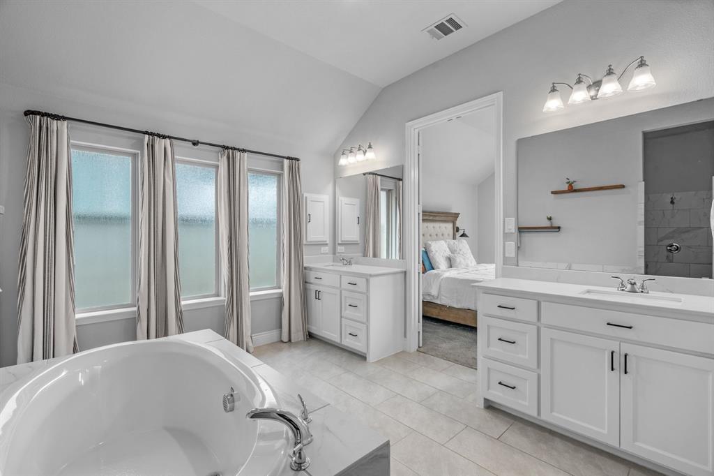2425 Robin Way Northlake, TX 76247 - Photo 18 of 40 a spacious bathroom with a double vanity sink a mirror a bathtub and window